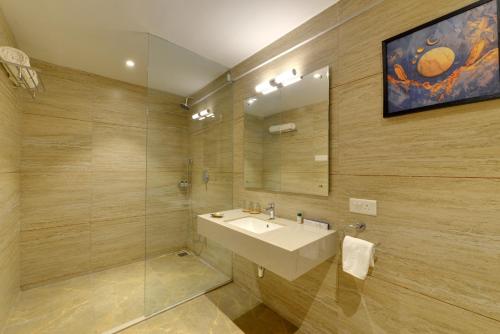 a bathroom with a sink and a glass shower at Iris Beacon Hotel in Rajkot