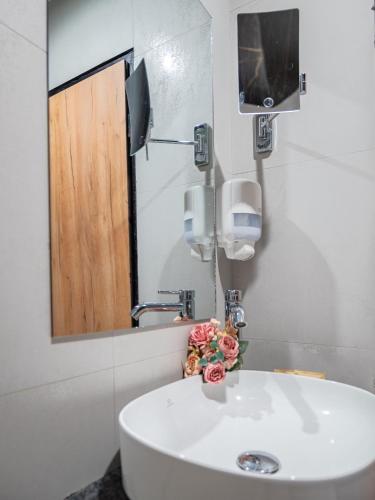 a bathroom with a white sink and a mirror at SPA Hotel Olymp in Velingrad