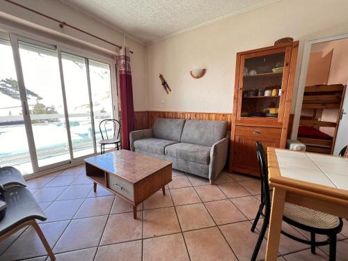una sala de estar con un sofá y una mesa en Appartement cosy à Bagnères-de-Bigorre, 34 m² avec balcon, en La Mongie