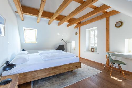 a bedroom with a large bed and a desk at Käpt'ns Hus in Ahrenshoop