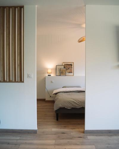 une chambre avec un lit dans une pièce aux murs blancs dans l'établissement Cavalier Loft Domaine de Greffeil, à Greffeil