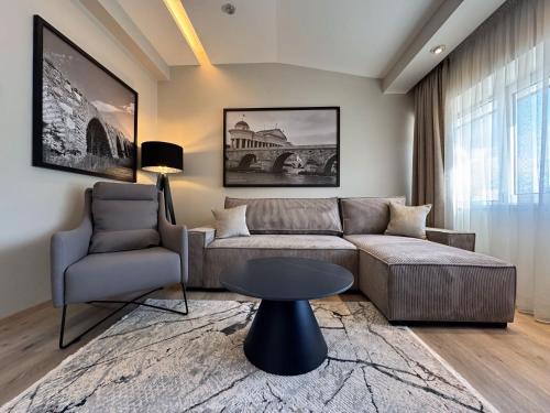 a living room with a couch and a table and a chair at Queen's Hotel - Zebra Centre in Skopje