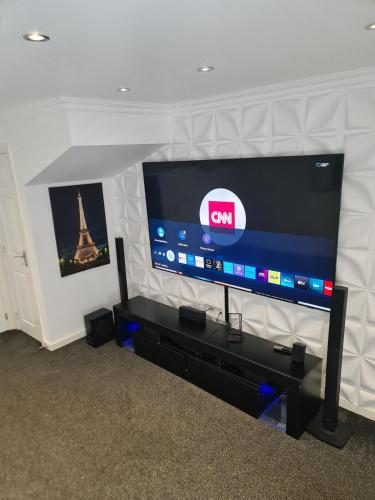 a large flat screen tv sitting on a wall at Very cosy 3 bedroom house close to city in Longford