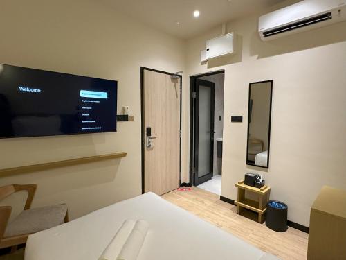 a room with a bed and a television on the wall at Hotel Mirda Puncak Alam in Bandar Puncak Alam