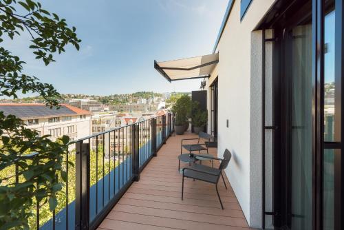 a balcony with chairs and a view of the city at EmiLu Design Hotel in Stuttgart
