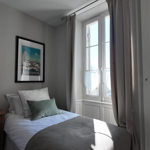 a bedroom with a bed and a window at Repos à Ribérac B&B in Ribérac