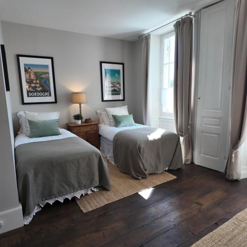 a bedroom with two beds and a window at Repos à Ribérac B&B in Ribérac