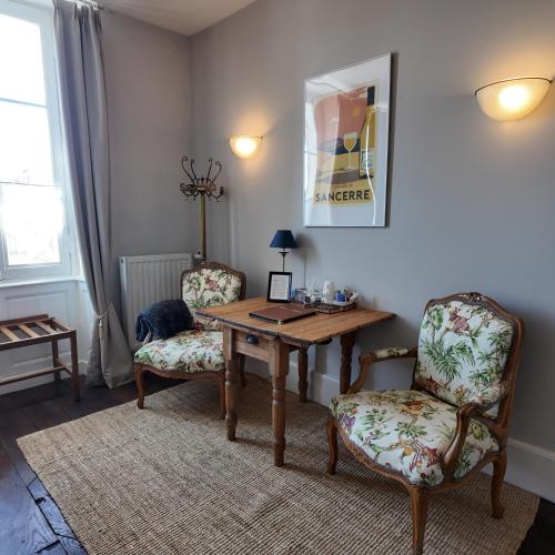 a dining room with a wooden table and two chairs at Repos à Ribérac B&B in Ribérac