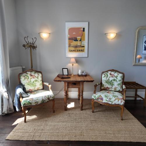 a living room with two chairs and a table and a lamp at Repos à Ribérac B&B in Ribérac