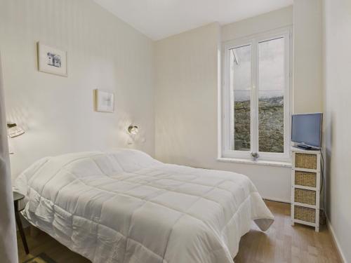 una camera da letto bianca con un letto e una finestra di Escapade à 2 au Pouliguen - 160m de la plage a Le Pouliguen