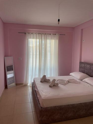 1 dormitorio con 1 cama grande y cortinas blancas en Andria Apartment, en Sarandë