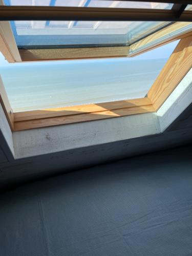 a window in a house with wooden beams at L'Escapade in Fort-Mahon-Plage