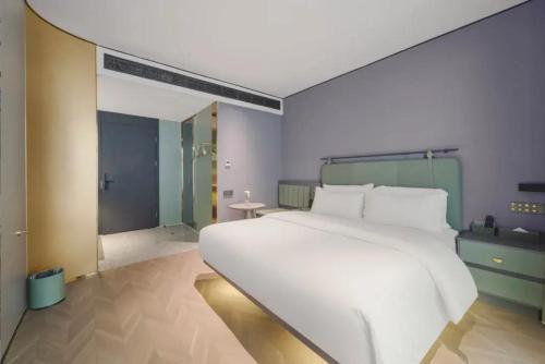 a large white bed in a room with a shower at G5 Shang Hotel - Kunming Railway Station Huan Cheng Nan Road Metro Station Branch in Kunming