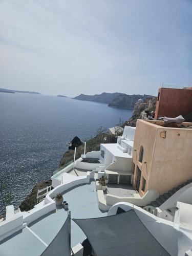 a group of white buildings with the ocean in the background at Phaos Oia Suites in Oia
