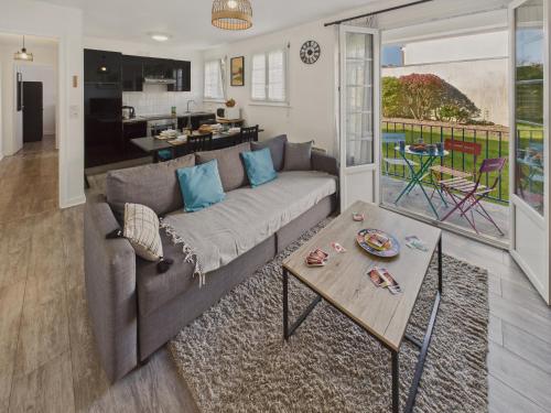 un salon avec un canapé et une table dans l'établissement Appartement pour 4 à 5 minutes de la plage, à Loctudy