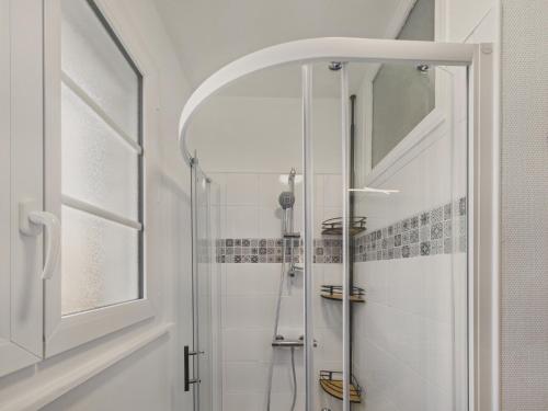 une douche avec une porte vitrée dans une salle de bain dans l'établissement Appartement pour 4 à 5 minutes de la plage, à Loctudy