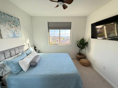 a bedroom with a blue bed and a ceiling fan at New 4 Bedroom Home with Ocean and Gorgeous Mountain Views in the gated community of Mauna Olu in Waianae