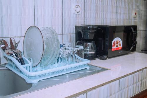a dish rack sitting on a counter next to a coffee maker at Appartements Haut Standing - Mimboman, Yaoundé in Yaoundé