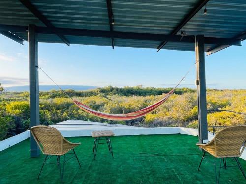 プエルト・ビジャミルにあるVilla Bella with private pool and high speed internetのパティオに椅子と景色が楽しめるハンモック
