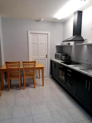 a kitchen with a table and two chairs and a stove at Bayview Lodge in Monargan Glebe