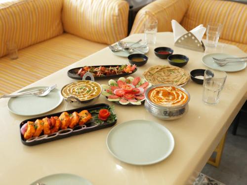 a table with plates of food on top at Hotel Thames in Zirakpur