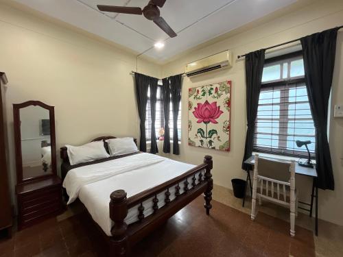 a bedroom with a bed and a mirror and a window at Sasha in Mumbai