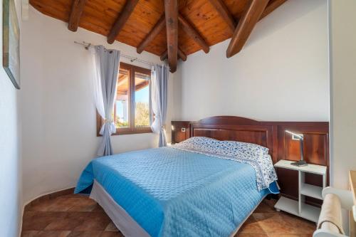 une chambre avec un lit bleu et une fenêtre dans l'établissement Loredana Home Holiday, à Bari Sardo