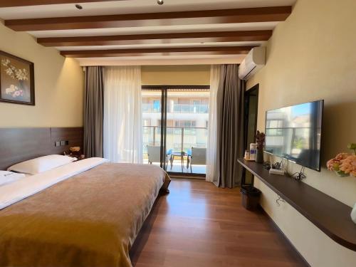 1 dormitorio con 1 cama grande y TV de pantalla plana en Luyu Shijian B&B, en Lijiang