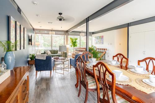 a dining room and living room with a table and chairs at Glass House retreat on scenic Bogue Falaya river in Covington