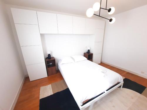 - une chambre avec des murs blancs et un lit blanc dans l'établissement Le Cosy Thurot : Proche Gare, Familial et Spacieux, à Dijon