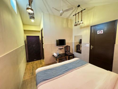 a bedroom with a bed and a television in it at Hotel O The Moon in New Delhi
