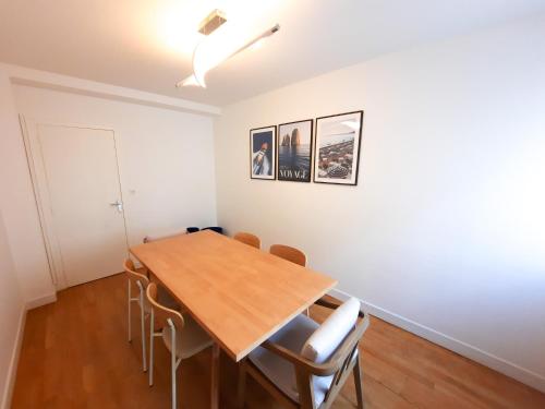 une salle à manger avec une table et des chaises en bois dans l'établissement Le Cosy Thurot : Proche Gare, Familial et Spacieux, à Dijon