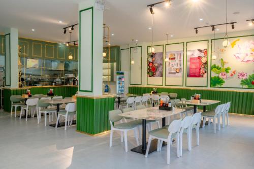 a dining area with tables and chairs in a restaurant at Osen Hotel - Grand World Phu Quoc in Phu Quoc