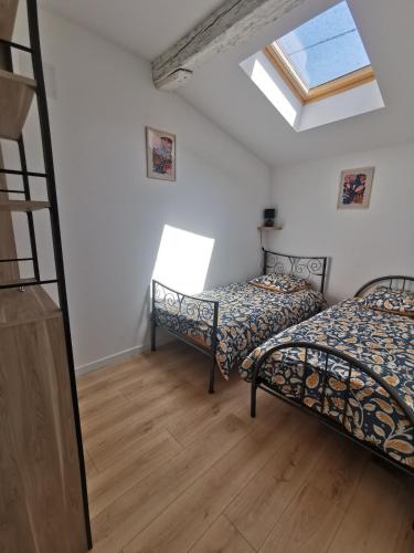 - une chambre avec 2 lits et une lucarne dans l'établissement Maison au coeur du village, à Grenade