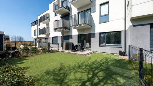 an apartment building with a lawn in front of it at Nad Zalewem, Sun & Snow in Dziwnówek