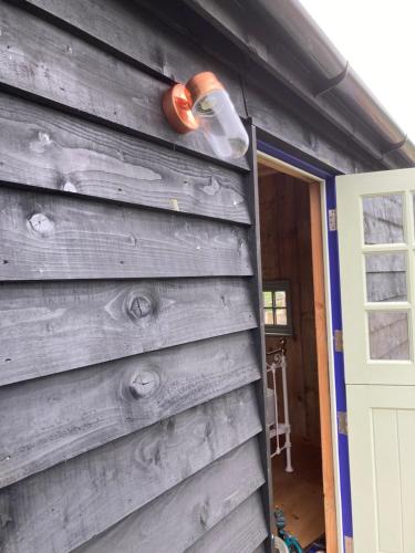 a building with a light on the side of it at Fox lodge Shepherd Hut Sidmouth in Sidmouth