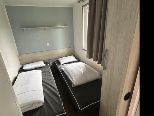 une petite chambre avec deux lits et une fenêtre dans l'établissement La Réserve 4 étoiles emplacement 445B 3CH 1SDB 8 personnes, à Gastes