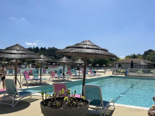 une piscine avec chaises et parasols et une piscine dans l'établissement La Réserve 4 étoiles emplacement 445B 3CH 1SDB 8 personnes, à Gastes