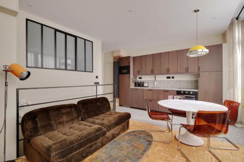 un salon avec un canapé et une table dans l'établissement Pick A Flat's apartment in Monmartre - Rue Etex, à Paris