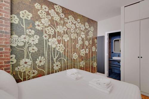 - une chambre avec un mur orné d'un papier peint à fleurs dans l'établissement Pick A Flat's apartment in Monmartre - Rue Etex, à Paris