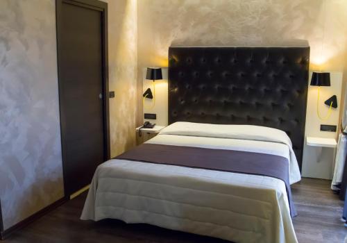 a bedroom with a large bed with a black headboard at Hotel Continental in Turin