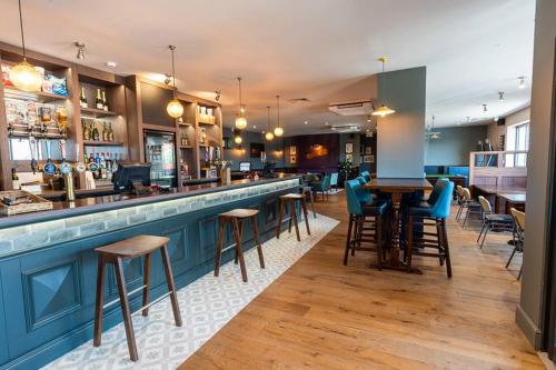 a bar with chairs and tables in a restaurant at Trieste, Waterside in Goodrington