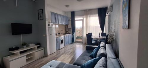 a living room with a large couch and a kitchen at Apartament COSTA in Mamaia