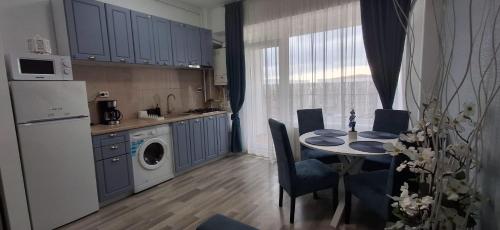 a kitchen with a table with chairs and a dining room at Apartament COSTA in Mamaia