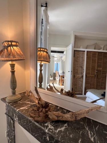 un miroir sur un comptoir avec deux lampes sur celui-ci, dans l'établissement Luxe et Charme - L'Alcôve - Plage à pieds - Meublé de tourisme 4 étoiles -, à Arcachon