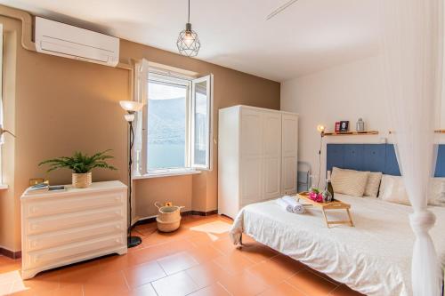 une chambre avec un lit blanc et une fenêtre dans l'établissement Ortensia Lake View Studio, à Oria