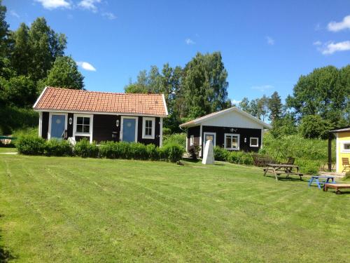 a small house in a yard with a grass field at Motel E4 Kolmården Apartments And Cottages in Kolmården