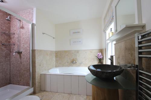 a bathroom with a bath tub and a sink at Cliff House, Cornwall in Padstow