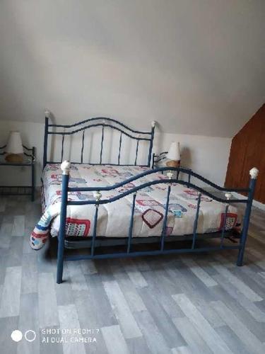 - une chambre dotée d'un lit avec un cadre bleu dans l'établissement Villa Les Bosquets, à Fort-Mahon-Plage