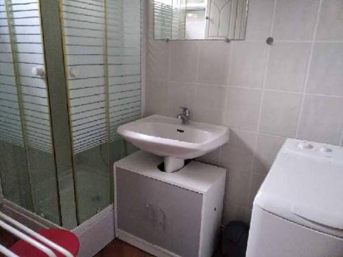 une salle de bain blanche avec un lavabo et une douche dans l'établissement Villa Les Bosquets, à Fort-Mahon-Plage